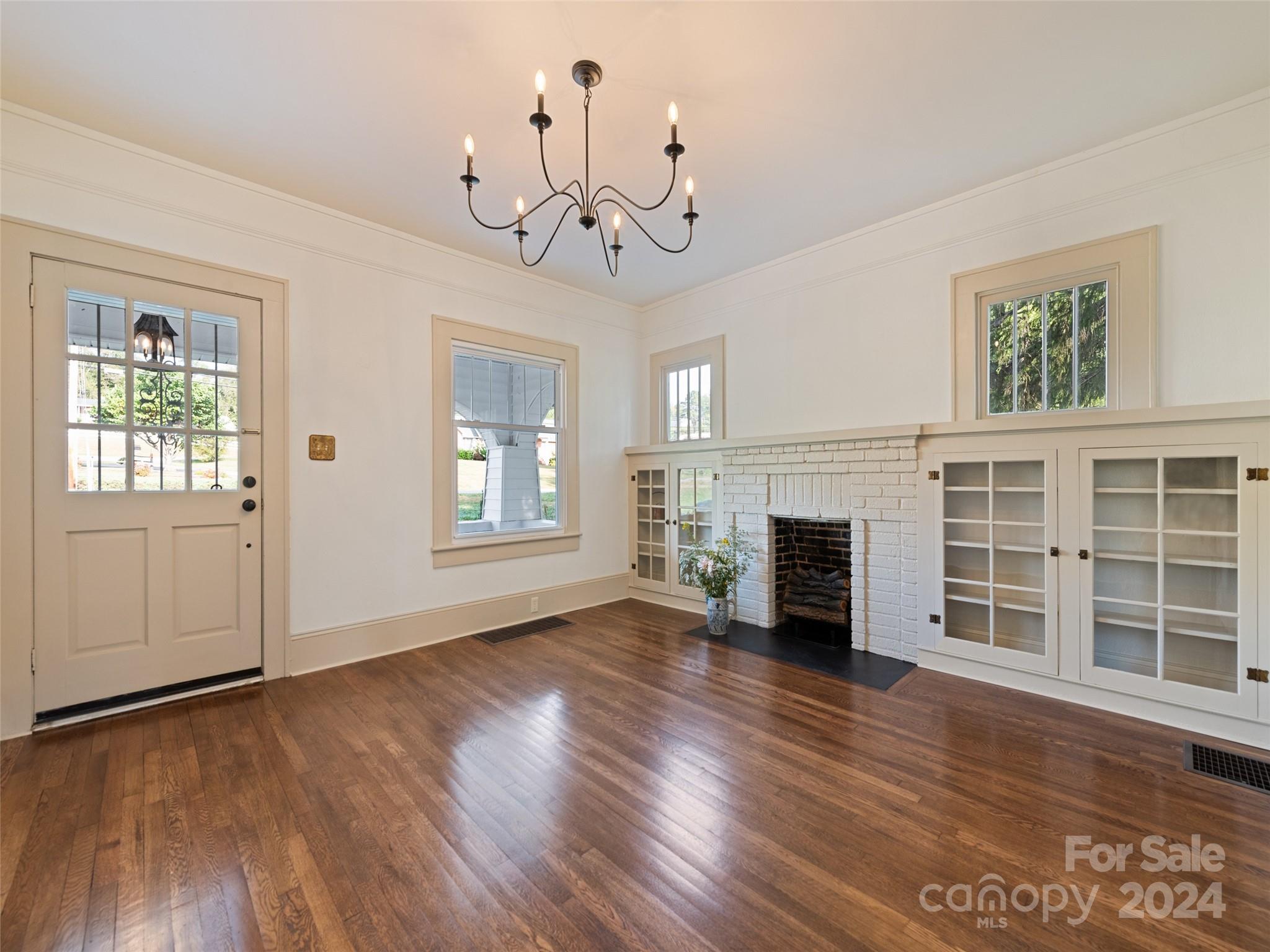 15 Scottdale Road Canton, NC 28716 - Photo 10 of 30 a view of a livingroom with wooden floor a fireplace and windows