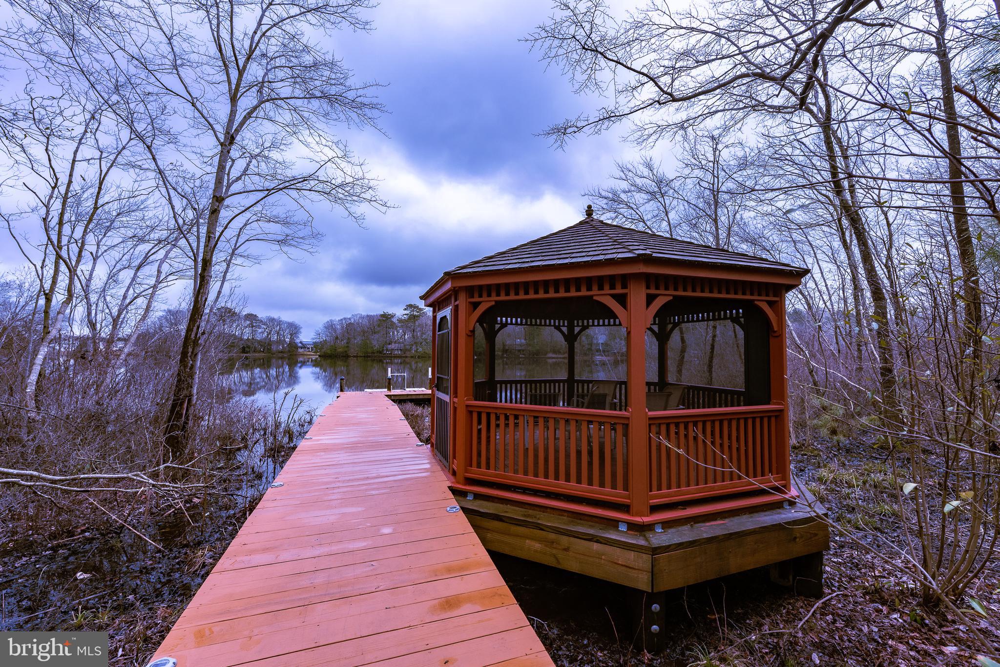 34148 Spring Brook Avenue Lewes, DE 19958 - Photo 75 of 77 a view of roof deck with large trees and wooden fence
