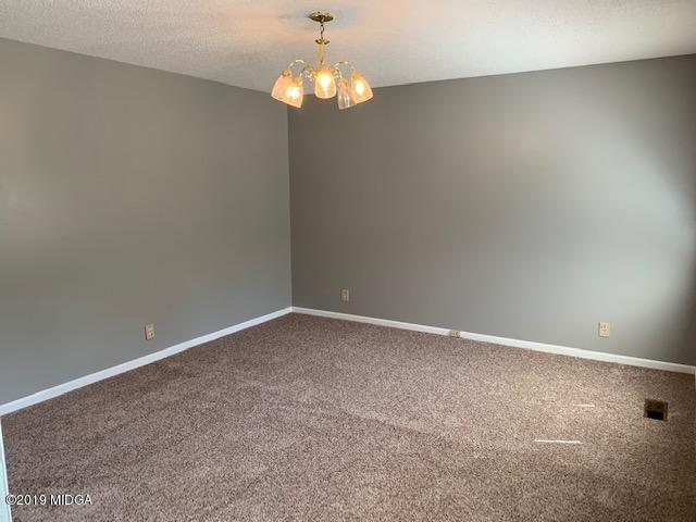 8449 Lower Thomaston Road Lizella, GA 31052 - Photo 3 of 9 a view of an empty room with a chandelier fan