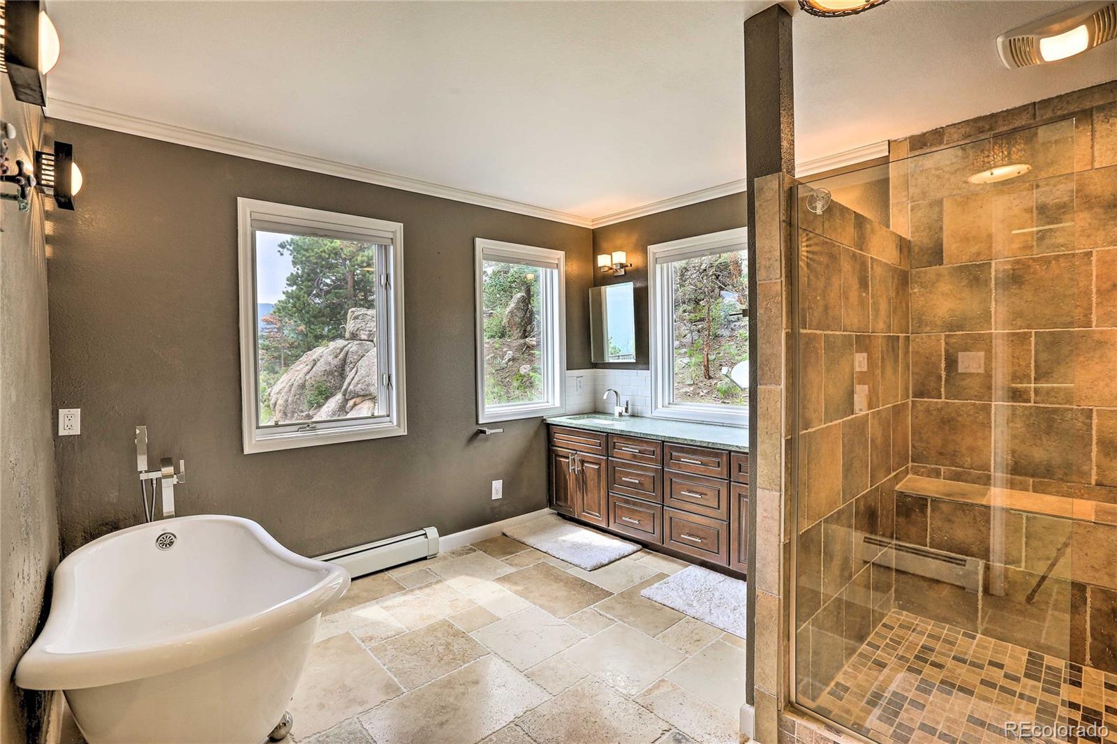 345 Old Sawmill Road Bailey, CO 80421 - Photo 14 of 39 a bathroom with a granite countertop sink a large mirror and a bathtub