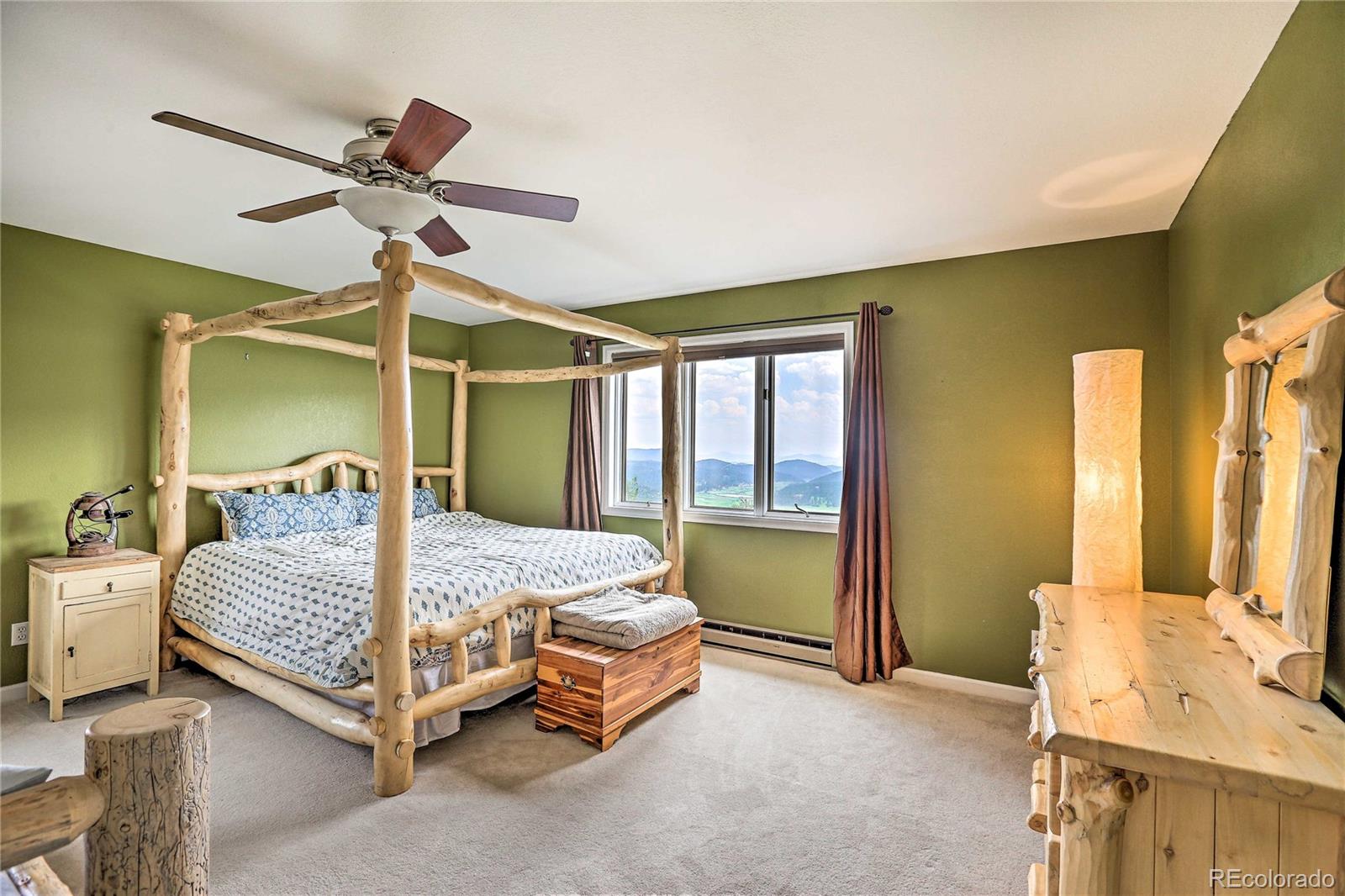 345 Old Sawmill Road Bailey, CO 80421 - Photo 18 of 39 a bedroom with a bed and a chandelier