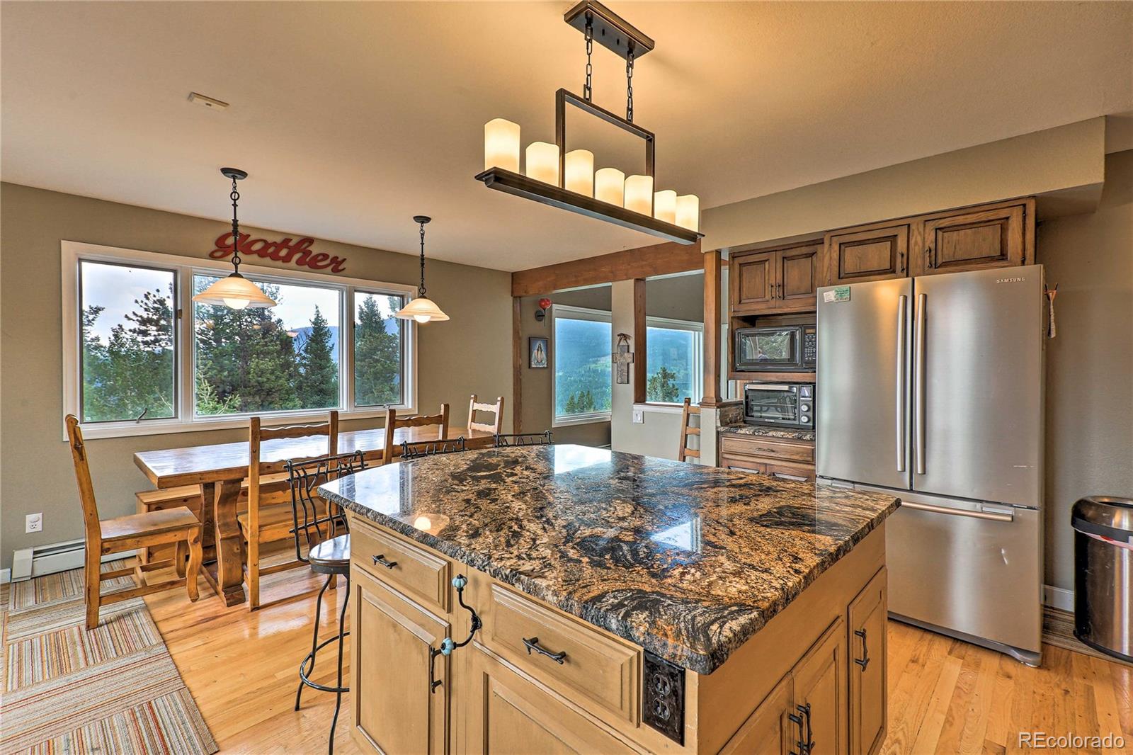 345 Old Sawmill Road Bailey, CO 80421 - Photo 7 of 39 a kitchen with kitchen island granite countertop a stove and a refrigerator