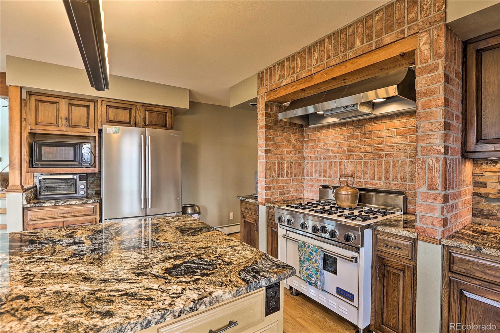 345 Old Sawmill Road Bailey, CO 80421 - Photo 8 of 39 a kitchen with stainless steel appliances granite countertop a stove and a refrigerator