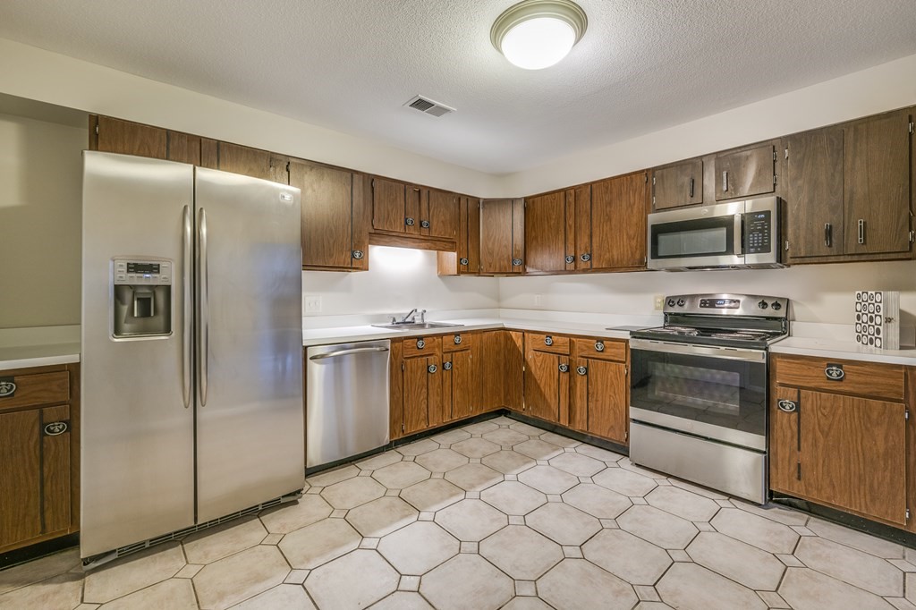 1002 Paradise Road, Unit PHE Swampscott, MA 01907 - Photo 9 of 23 a kitchen with granite countertop a refrigerator and a stove top oven