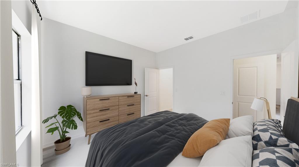 3033 Juniper Way Naples, FL 34112 - Photo 12 of 18 a bedroom with a bed and a flat screen tv