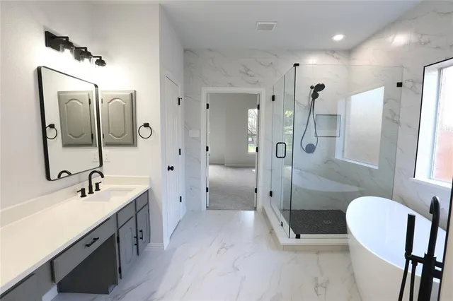 a spacious bathroom with a shower sink and mirror