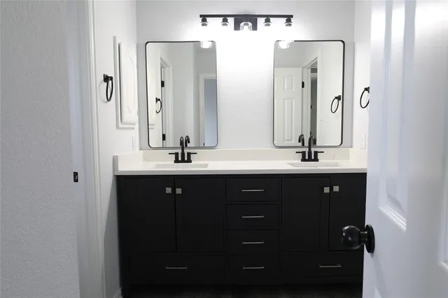 a bathroom with a double vanity sink and mirror