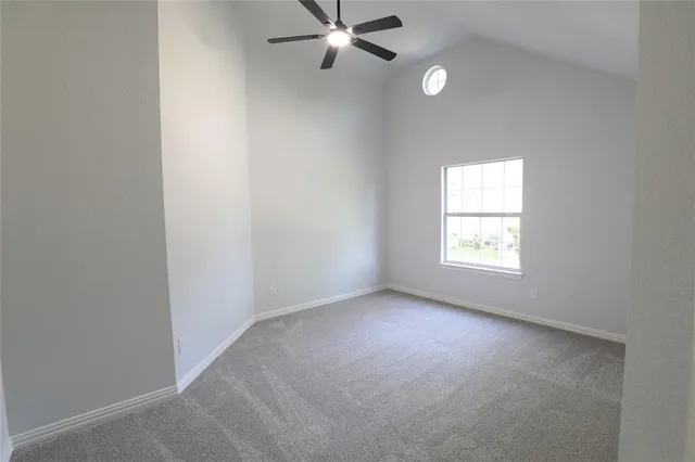 an empty room with a window and a fan