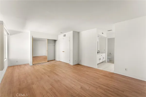 a view of an empty room with wooden floor