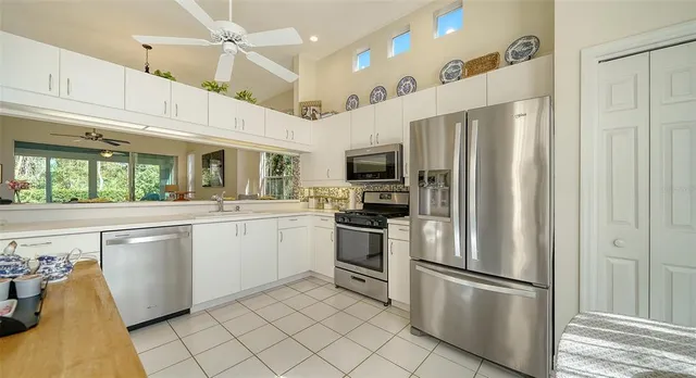 a kitchen with white cabinets stainless steel appliances and a refrigerator