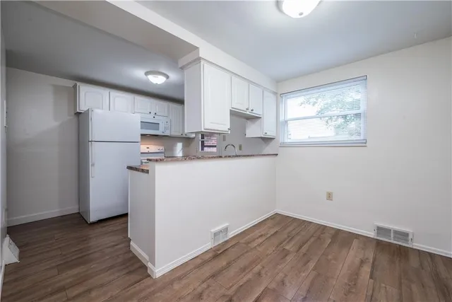 a kitchen with a refrigerator a sink and cabinets