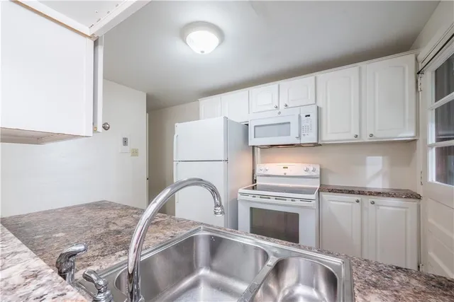 a kitchen with white cabinets and a refrigerator