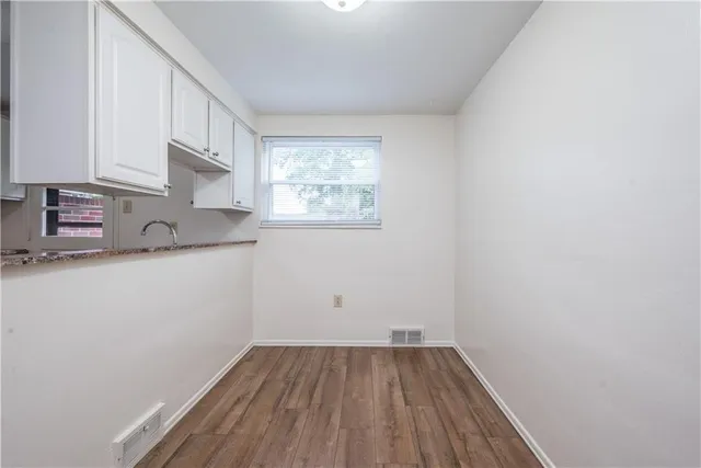 a view of a kitchen with wooden floor and electronic appliances