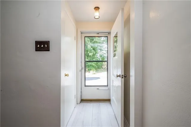 a view of a hallway with wooden floor and a bathroom