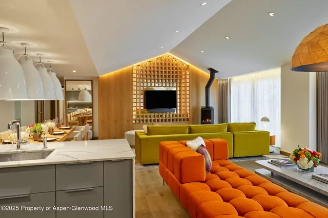 a living room with blue lights with furniture and a flat screen tv