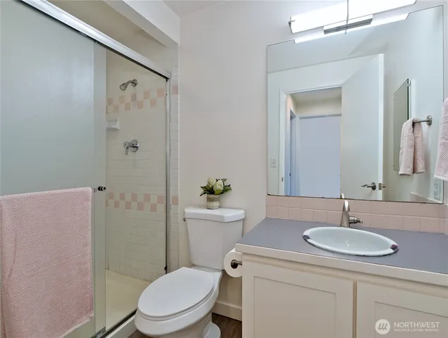 a bathroom with a sink toilet a mirror and shower