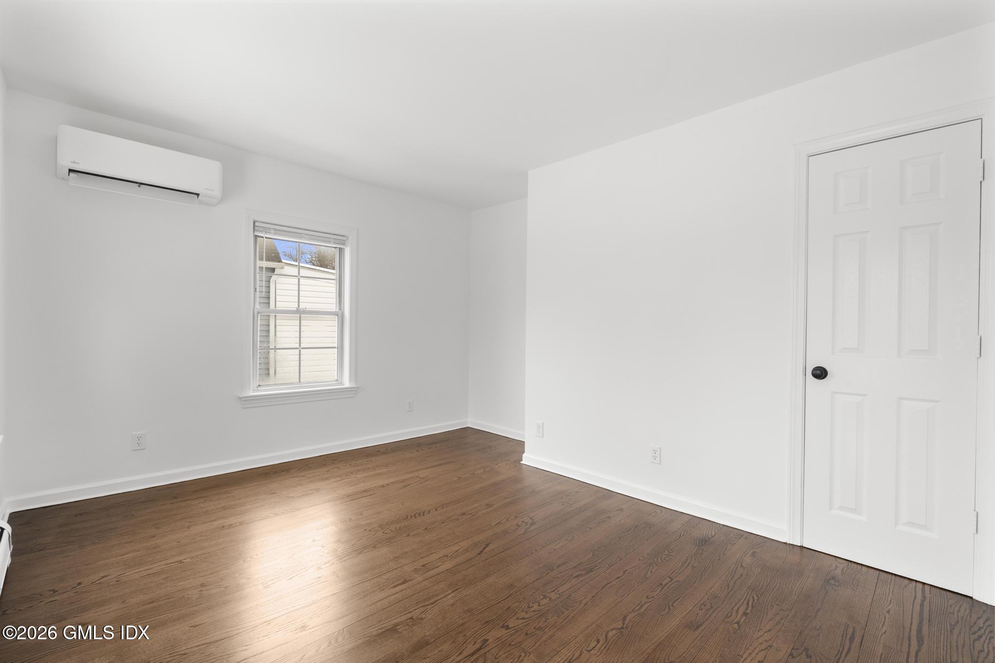 134 River Rd Extension, Unit 2 Cos Cob, CT 06807 - Photo 11 of 19 an empty room with wooden floor and windows