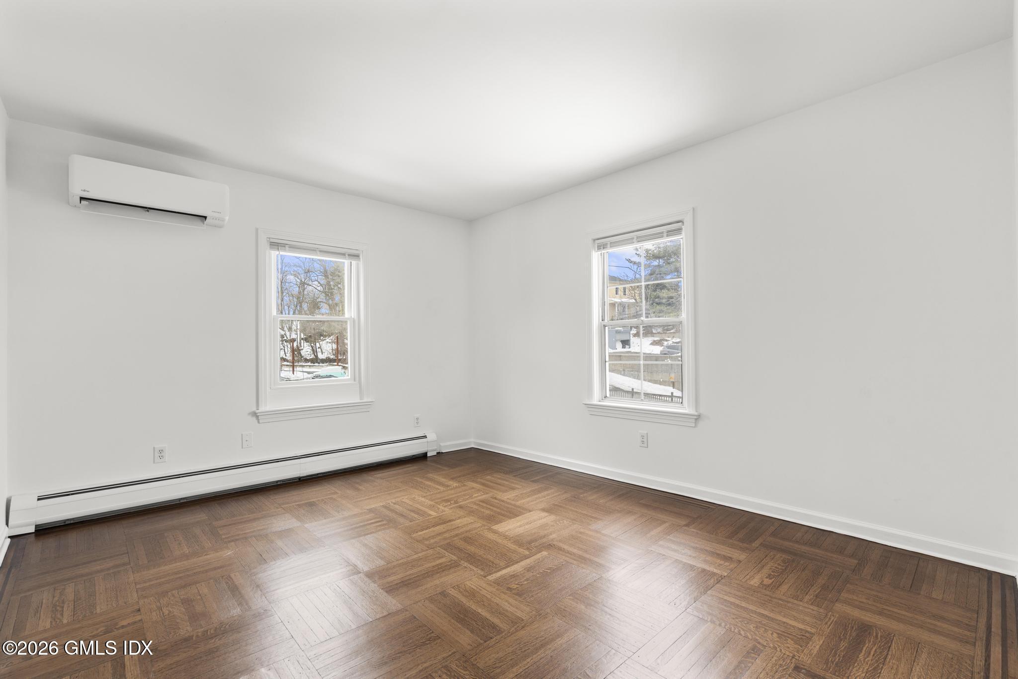 134 River Rd Extension, Unit 2 Cos Cob, CT 06807 - Photo 7 of 19 an empty room with wooden floor and windows