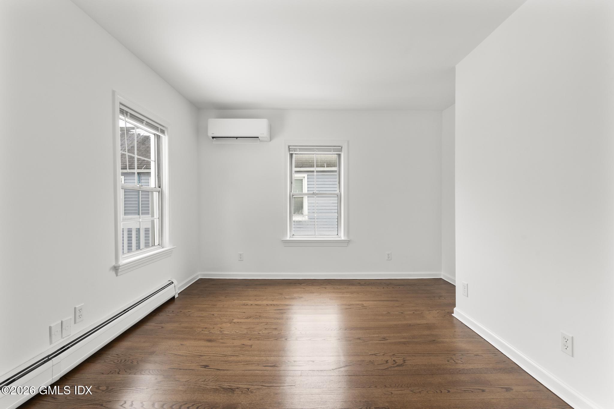 134 River Rd Extension, Unit 2 Cos Cob, CT 06807 - Photo 8 of 19 an empty room with wooden floor and windows