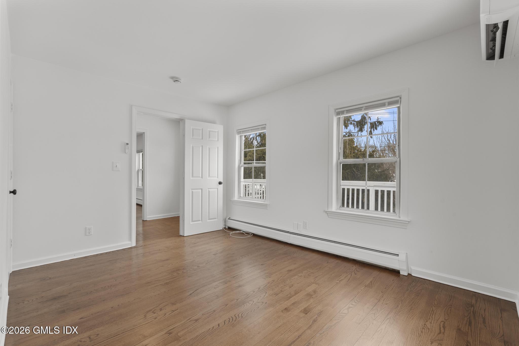 134 River Rd Extension, Unit 2 Cos Cob, CT 06807 - Photo 9 of 19 a view of an empty room with a window and wooden floor