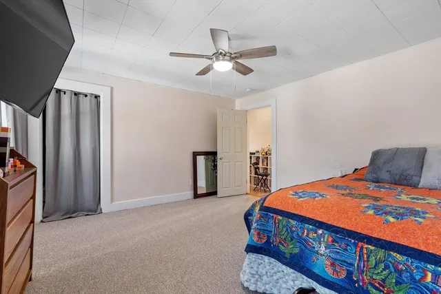a bedroom with furniture and a chandelier fan