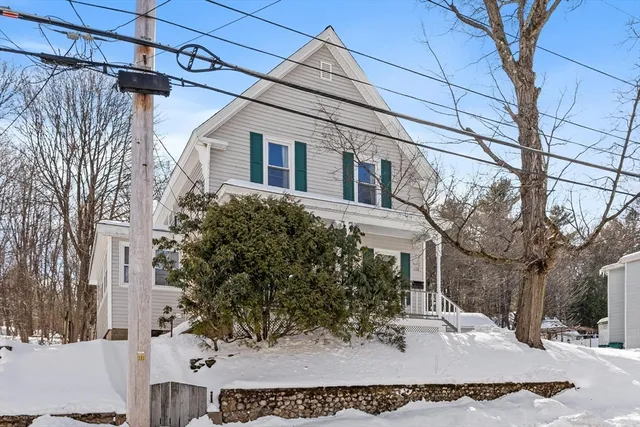 a view of a white house with a large tree