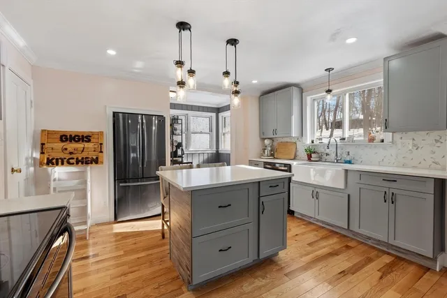 a large kitchen with kitchen island a island a stove a sink a dining table and chairs