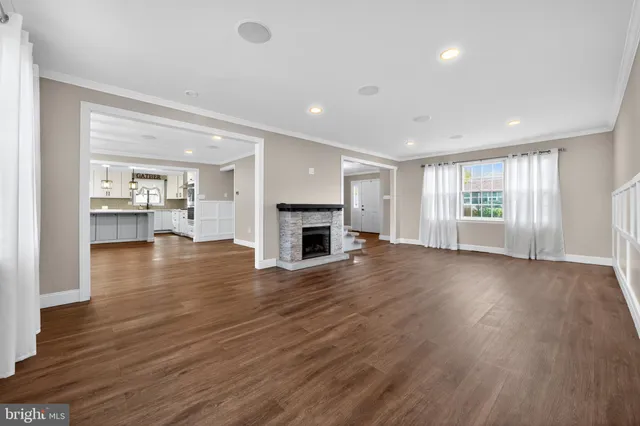 an empty room with wooden floor and fireplace