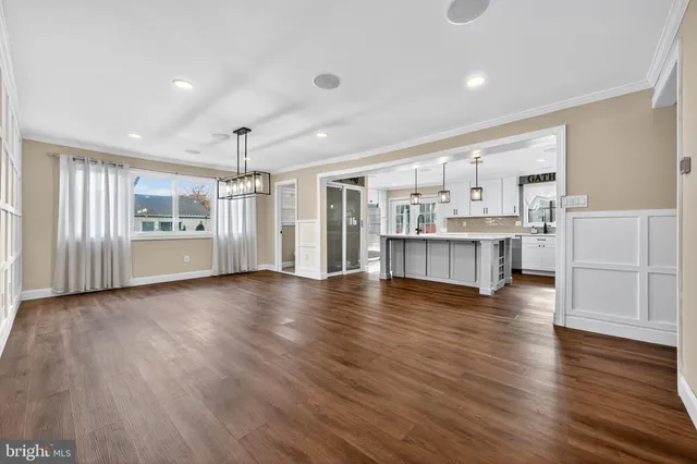 a view of a kitchen with a kitchen island wooden floor and stainless steel appliances