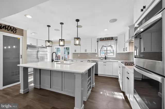 a kitchen with white cabinets appliances and wooden floor
