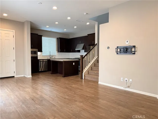 a view of kitchen with stainless steel appliances kitchen island wooden floor and window