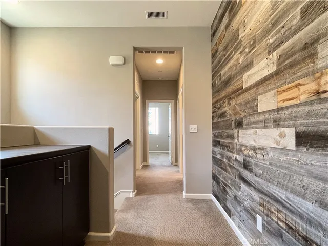 a view of a hallway to rooms and stairs