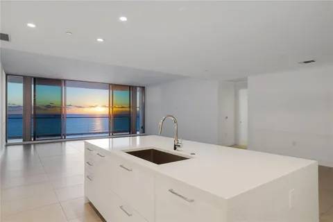 a kitchen with stainless steel appliances a sink and a hard wood floor