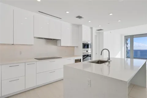 a kitchen with kitchen island a sink stainless steel appliances and cabinets