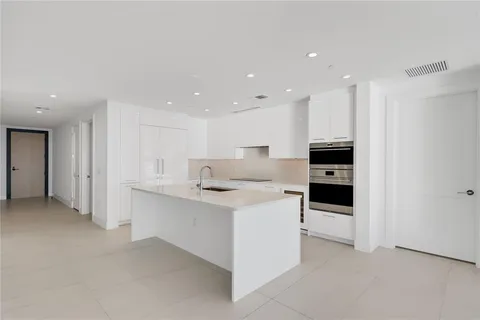 a kitchen with stainless steel appliances kitchen island sink refrigerator and stove