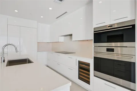 a kitchen with stainless steel appliances a stove microwave and sink