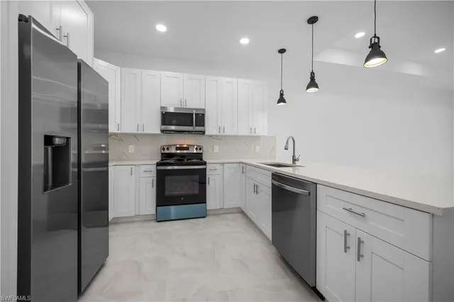 a kitchen with a refrigerator and a stove top oven