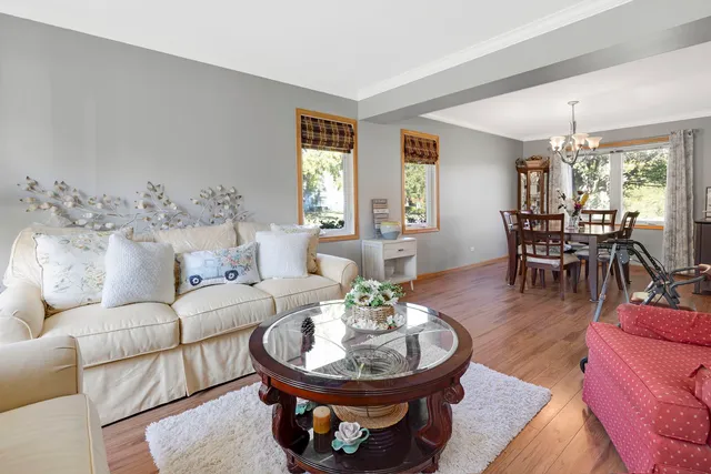 a living room with furniture a dining table and a chandelier
