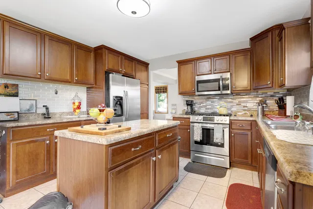 a kitchen with stainless steel appliances granite countertop a stove top oven a sink dishwasher and cabinets with wooden floor