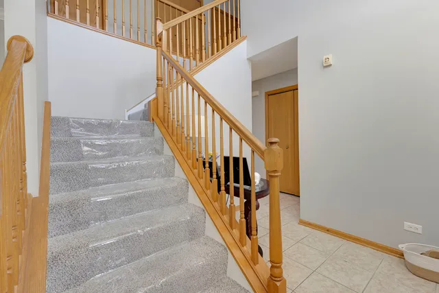 a view of staircase with wooden floor and white walls