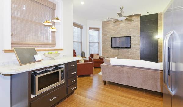 3529 North Reta Avenue, Unit 3R Chicago, IL 60657 - Photo 3 of 14 a view of kitchen with stainless steel appliances wooden floor and living room view