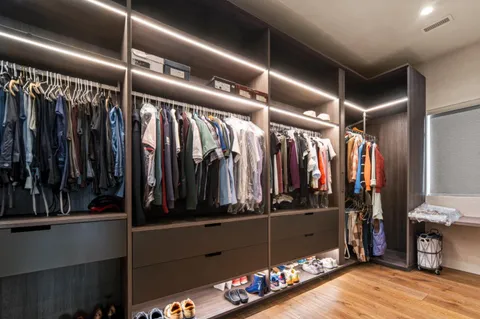 a view of walk in closet with clothes and shoes