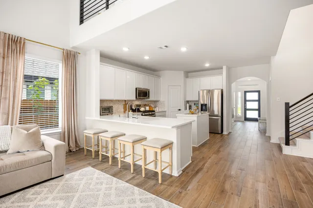 a large white kitchen with a large window and stainless steel appliances