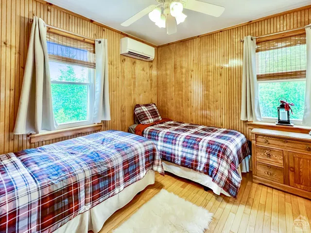 a bedroom with a bed and a dresser next to a window