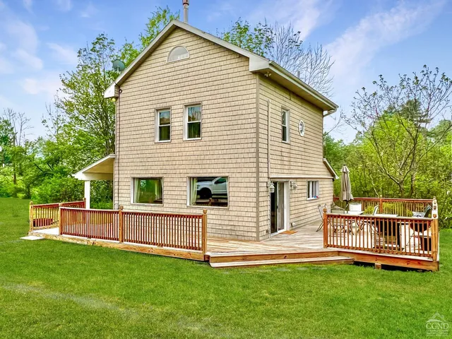 a front view of a house with a yard and deck