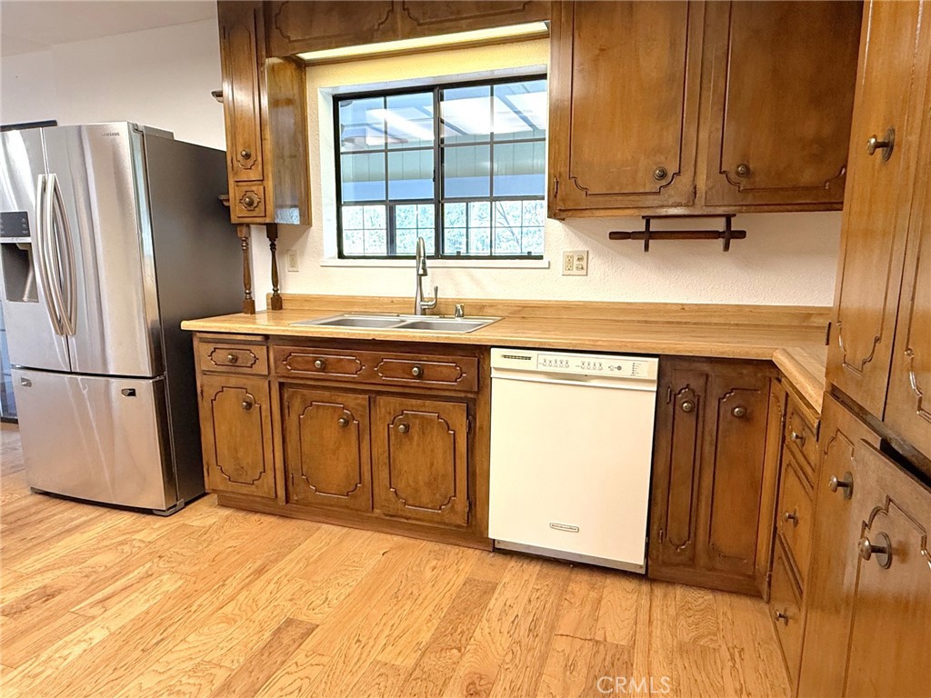 5636 East Whitlock Road Mariposa, CA 95338 - Photo 18 of 41 a kitchen with stainless steel appliances granite countertop a refrigerator a sink and wooden cabinets