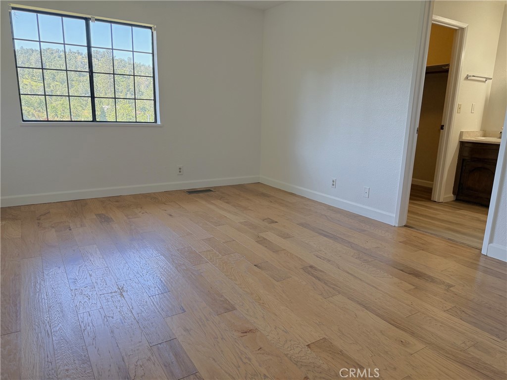 5636 East Whitlock Road Mariposa, CA 95338 - Photo 19 of 41 an empty room with wooden floor and windows
