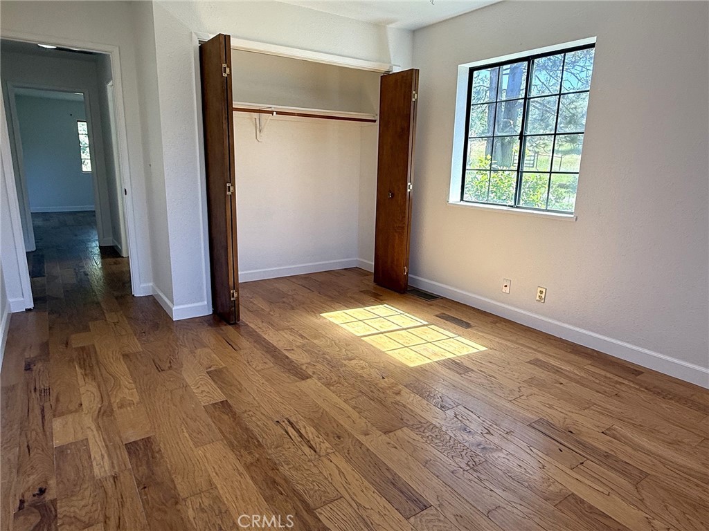 5636 East Whitlock Road Mariposa, CA 95338 - Photo 27 of 41 an empty room with wooden floor and windows