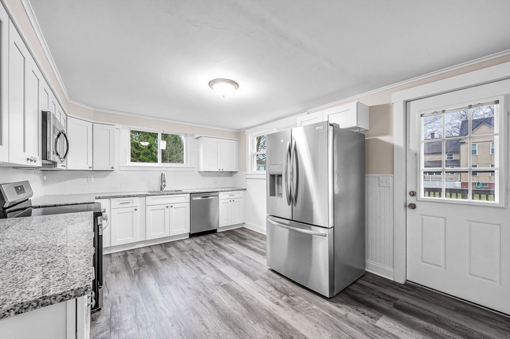 a kitchen with a refrigerator a sink and wooden cabinets