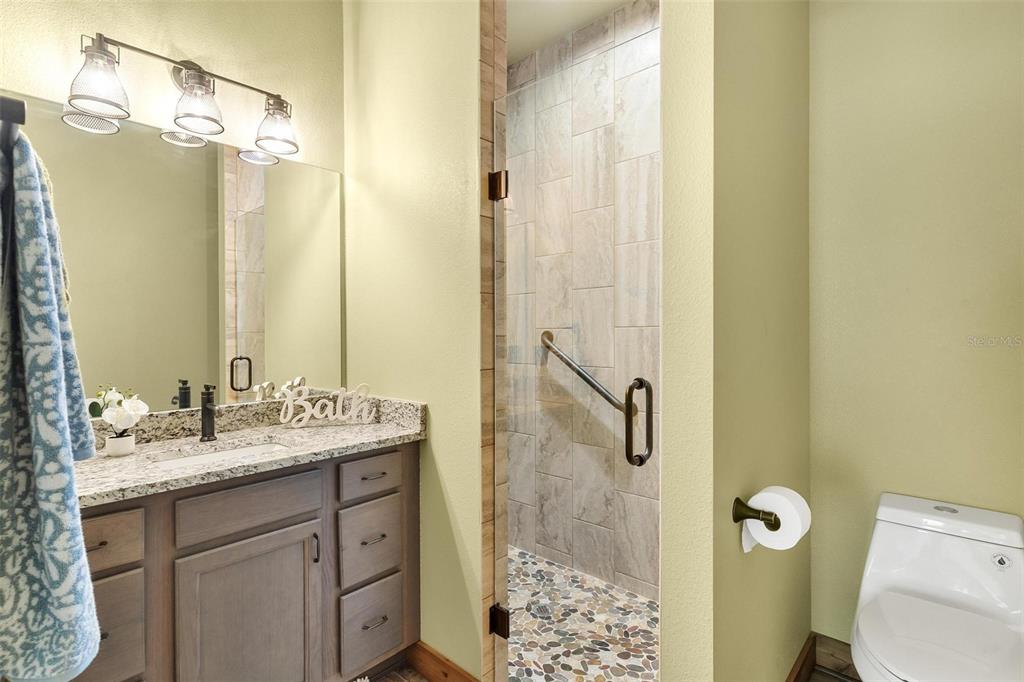 37590 Rolling Acres Road Lady Lake, FL 32159 - Photo 16 of 30 a bathroom with a granite countertop sink toilet and shower